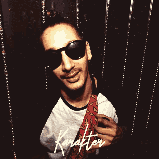 a man wearing sunglasses and a tie with the word karakter written on it