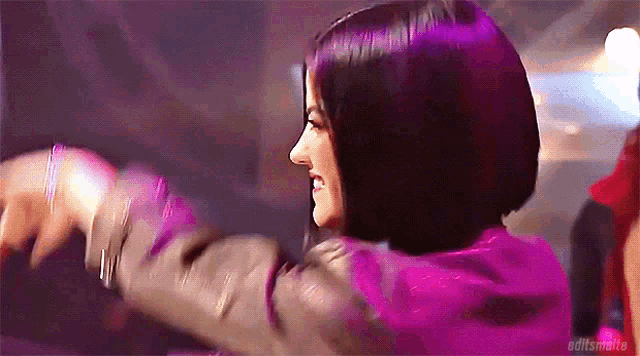 a woman in a pink jacket is dancing with her arms outstretched
