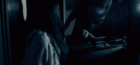 a monster is coming out of a doorway in a dark room .