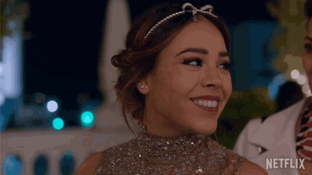 a woman is smiling in front of a netflix sign