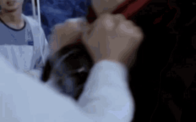 a man is tying a red tie around his neck .