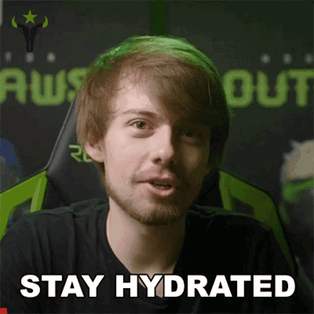 a man with a beard says " stay hydrated " in front of a green chair