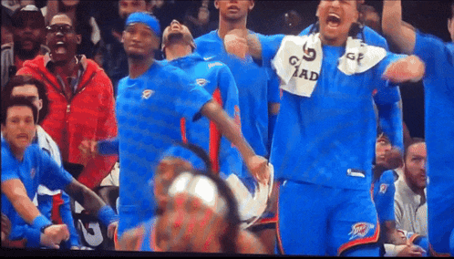 a group of basketball players wearing blue uniforms with the number 5 on their shirts