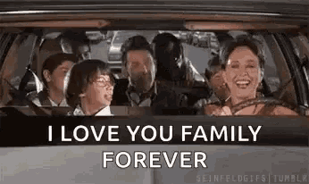 a family is sitting in the back seat of a car and the woman is driving .