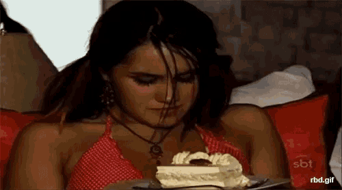 a woman is eating a piece of cake with a spoon .