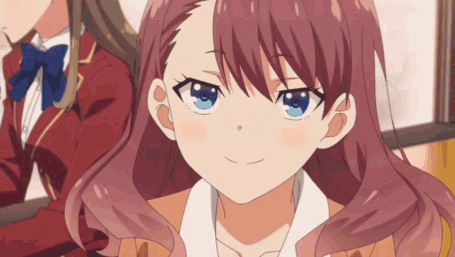 a girl with red hair and blue eyes is smiling in a classroom