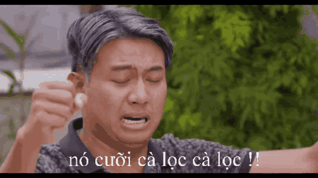 a man with gray hair is crying with the words no cuoi ca loc ca loc written below him