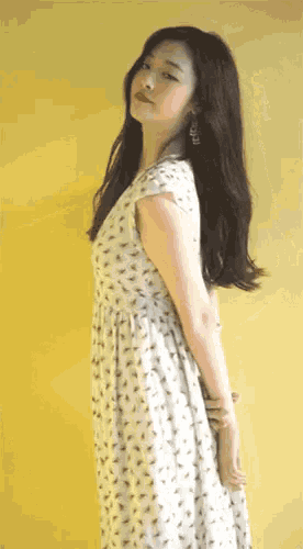 a woman in a white dress with a yellow background