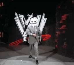 a man in a suit and tie with a skull mask on his face