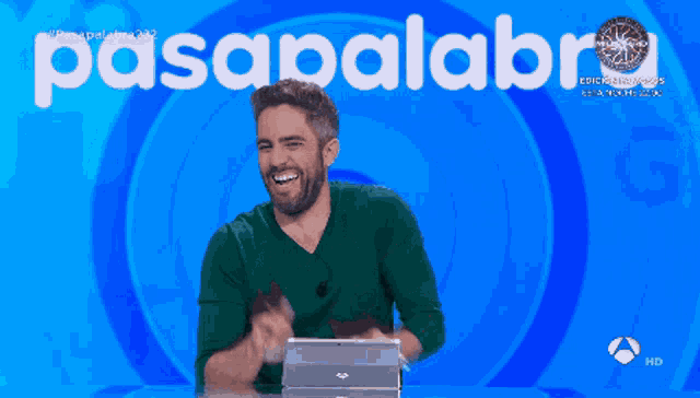 a man is laughing in front of a blue background with the word pasapalabra