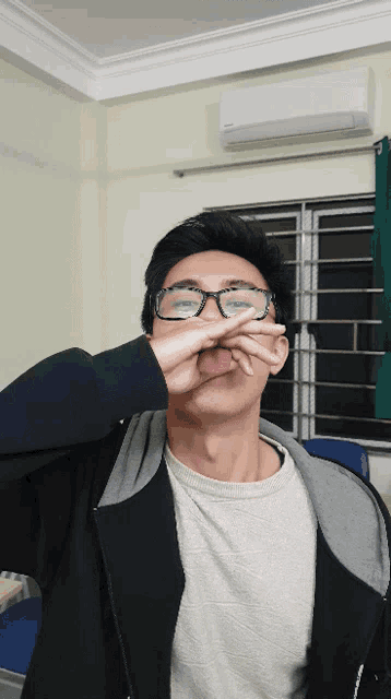 a young man wearing glasses is making a face