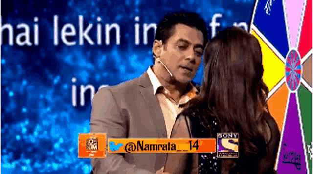 a man and woman are kissing in front of a sign that says hai lekin in