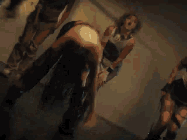 a group of women are dancing in a dark room and one of them is wearing black boots