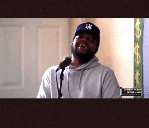 a man singing into a microphone wearing a hat that says ny
