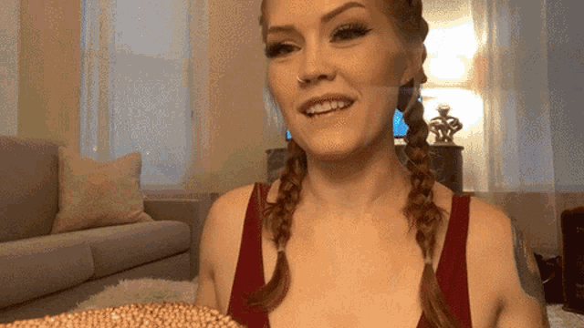 a woman with pigtails and a nose ring is smiling
