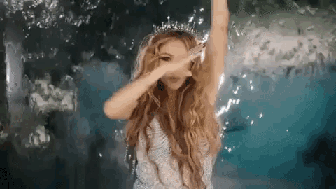 a woman in a white dress and tiara is dancing in a pool .