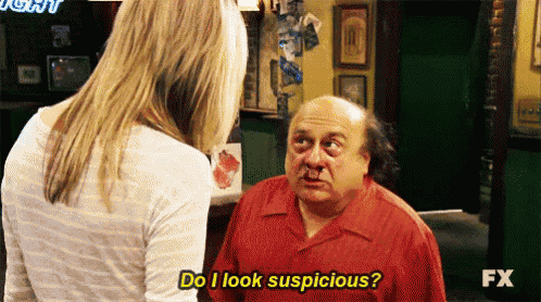 a man in a red shirt is talking to a woman who is asking him if he looks suspicious