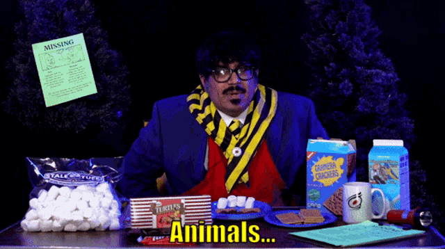 a man sitting at a table with a bag of turtle 's marshmallows in front of him