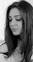 a black and white photo of a woman with long hair looking down with her eyes closed .