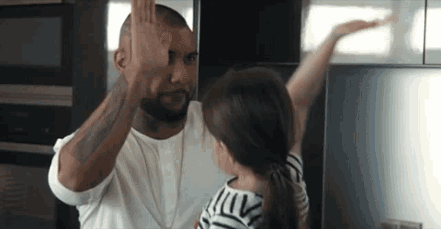 a man and a little girl giving each other a high five