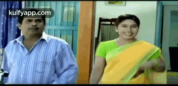 a man and a woman are standing next to each other and smiling .