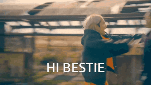 a woman in a black jacket says hi bestie in a blurry photo