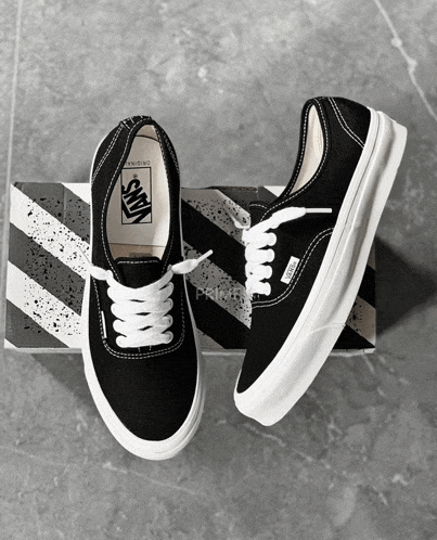 a pair of black vans shoes with white laces