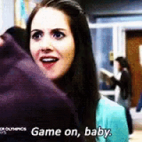a woman in a blue shirt is holding a purple blanket and says `` game on baby '' .