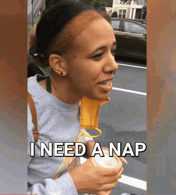 a woman with a mask around her neck says " i need a nap "
