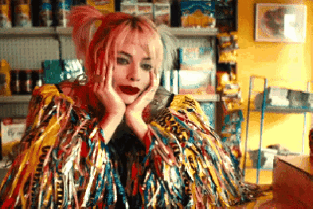 a woman with pink hair is wearing a colorful feathered coat