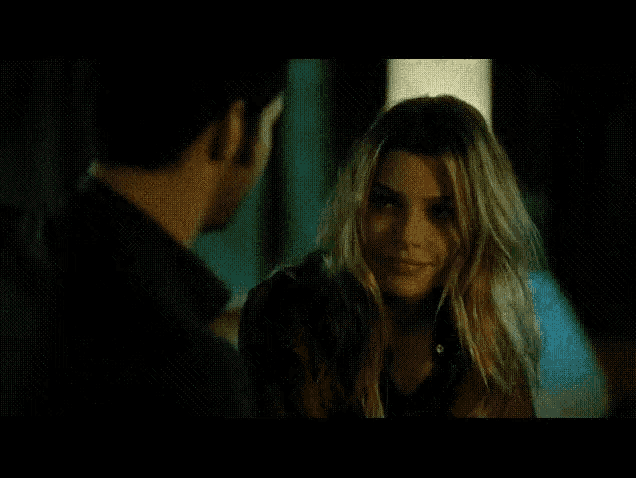 a man and a woman are kissing in the dark