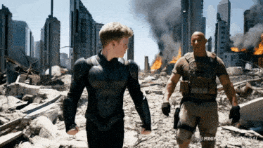 a man in a black suit stands next to a boy in a black suit in front of a destroyed city