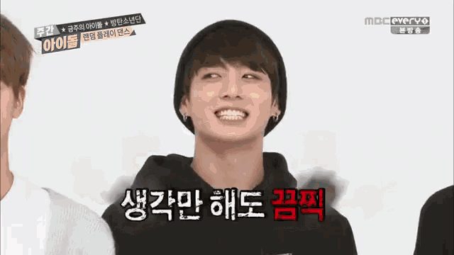 a man wearing a beanie and a hoodie is smiling in a foreign language