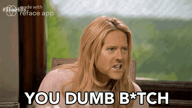 a woman sitting at a table says you dumb bitch