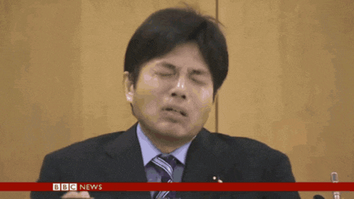 a man in a suit and tie is crying in front of microphones with bbc news in the upper right corner