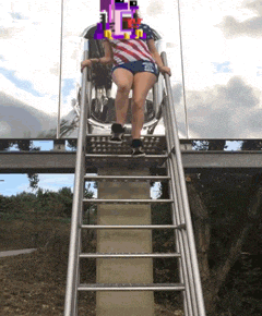 a woman is going down a slide with a pixelated face on her head