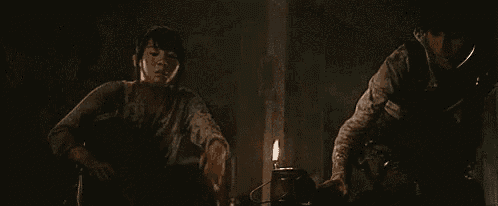 two people are standing next to each other in a dark room .