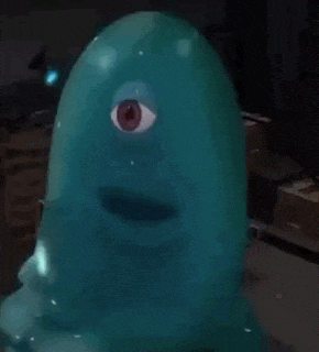 a blue balloon with a red eye on it is sitting on a table .