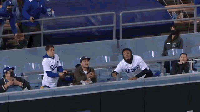 a man in a dodgers jersey throws a baseball