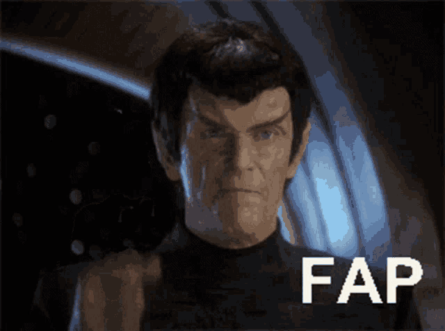 a man in a black shirt is pointing at the camera with the word fap behind him