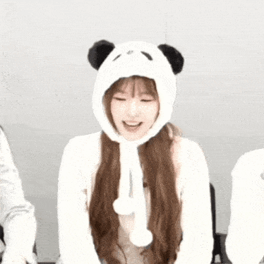 a girl wearing a panda hat is smiling