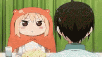 a boy and a girl are sitting at a table with a plate of food and a glass of water .