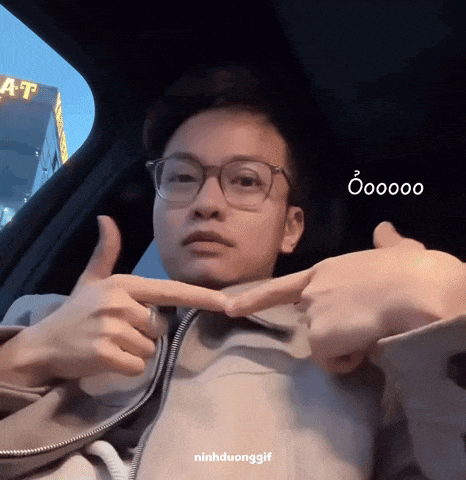 a man wearing glasses is giving a thumbs up in a car with the words ninhduonggif below him