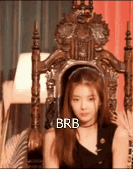 a woman is sitting in a chair with the words brb written on the bottom