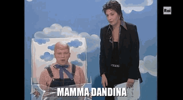 a woman standing next to a man in a box with the words mamma dandina written on the screen