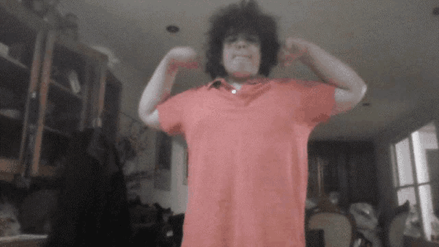 a person in a red shirt is standing in a living room
