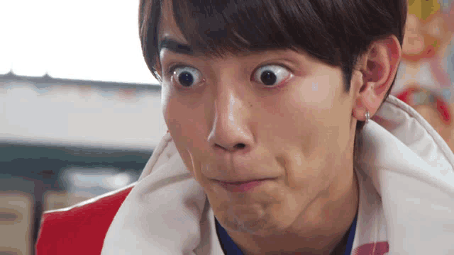 a close up of a man making a funny face with his eyes wide open