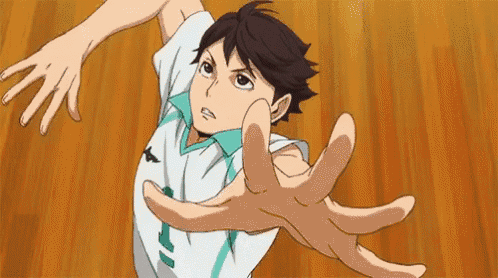 a volleyball player is reaching out to catch a ball on a wooden floor .