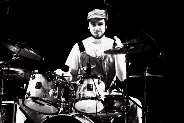 a man playing drums with a hat that says ' a ' on it