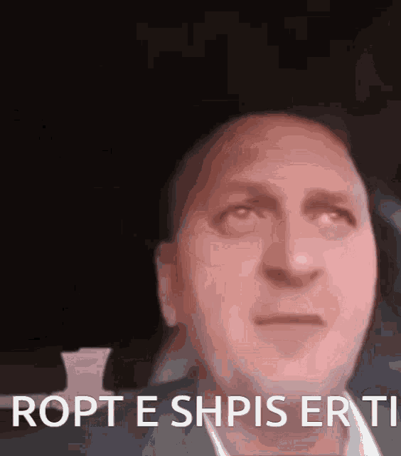 a close up of a man 's face with the words ropt e shpis erti below it